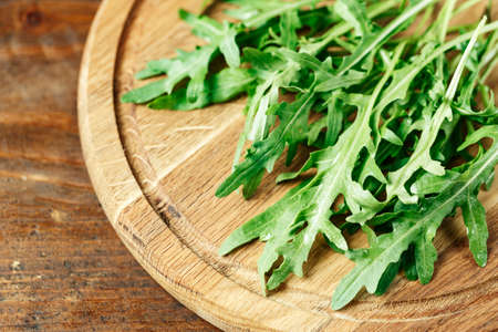 fresh arugula close-up on a round cutting board. traditional Italian seasoning
の写真素材