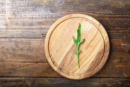 fresh arugula on a round cutting board. traditional Italian seasoning. space for textの写真素材