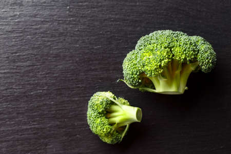 Fresh raw broccoli inflorescence on the table on a black background. space for textの写真素材