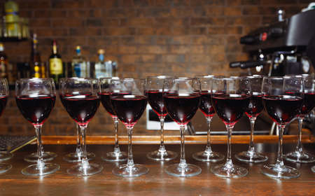 Glasses with red wine are lined up on the bar. welcome drinkの写真素材