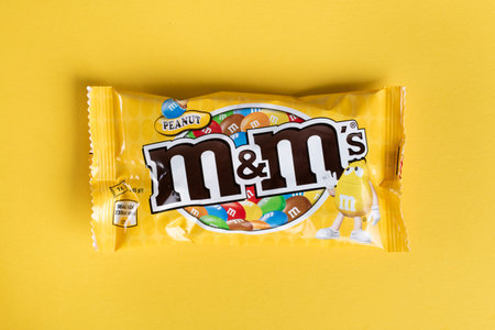 Ukraine, Kiev March 29, 2018.  Closeup of  M&M's milk chocolate candies made by Mars Inc. on yellow backgroundのeditorial素材
