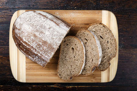 Sliced homemade black bread close-up on a wooden background. space for text