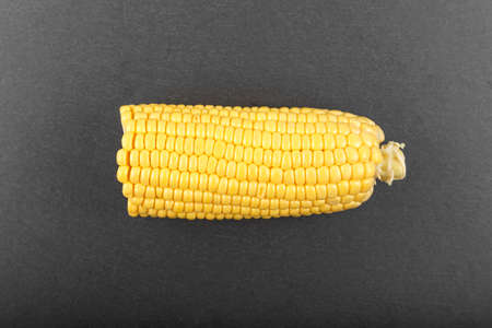 Fresh corn on cobs on black board, closeup, top view 