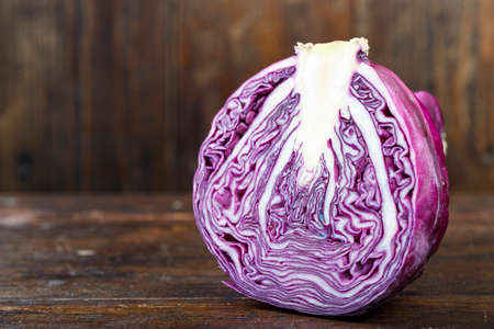 purple cabbage cut in half on wooden brown background. clearly visible texture of the vegetable. space for textの写真素材