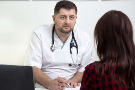male doctor in uniform and with a stethoscope, on reception with a patient