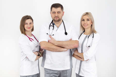 three doctors with a stethoscope are smiling. a man and two young girls are photographed on a white background.の写真素材
