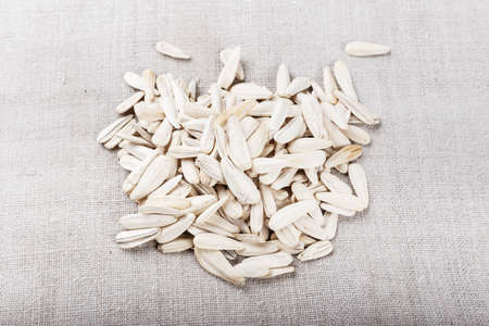 white sunflower seeds scattered on a linen napkin. space for textの写真素材