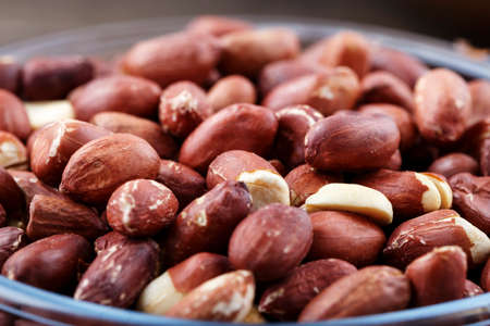 A lot of peeled peanuts are scattered as a background. space for text