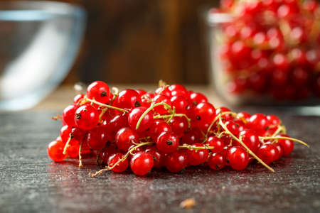 ripe red currants on the table, on a black background. space for text