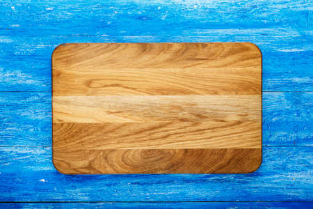 Rectangular wooden cutting board on a wooden background. space for text
の写真素材
