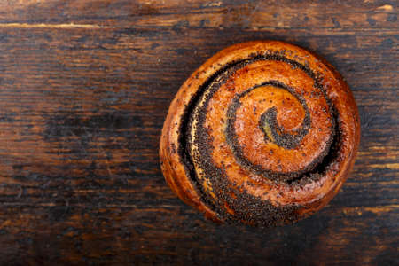 sweet bun with poppy on a wooden background 