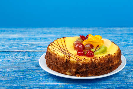 Delicious fruit cake on a blue background. Birthday fun holiday