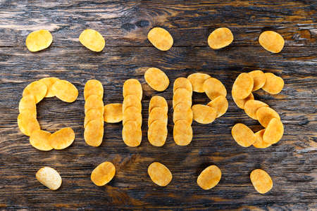 Potato chips on a wooden table. view from above