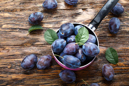 harvest fresh ripe plum in a saucepan on the table. cooking organic dessertの写真素材