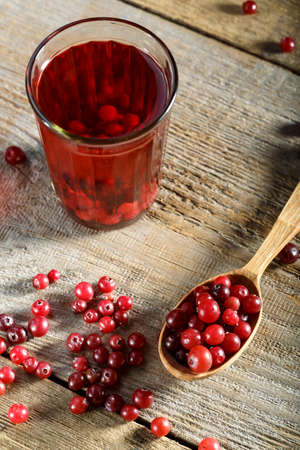vitamin drink cranberry juice, and raw berries on a simple wooden table. refreshing drinkの写真素材