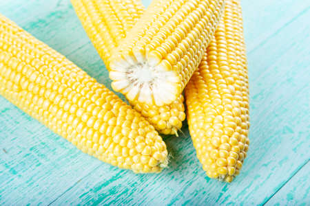 Fresh corn on cobs on rustic wooden table, closeup