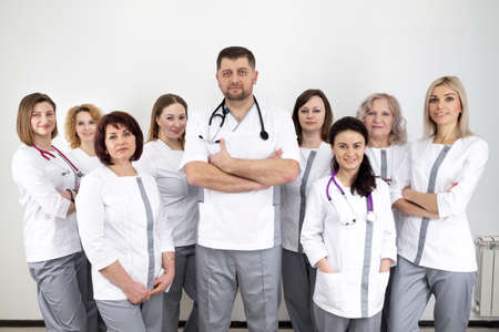Chief doctor with a team of women doctors. doctors in modern uniform and with special medical equipmentの写真素材