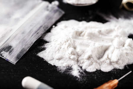 drug white powder sprinkled on a black table. next syringe. dangerous illegal business. place for text
の写真素材