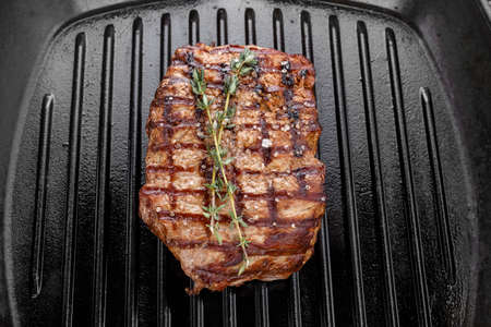 fresh beef steak with spices in a grill pan. place for text