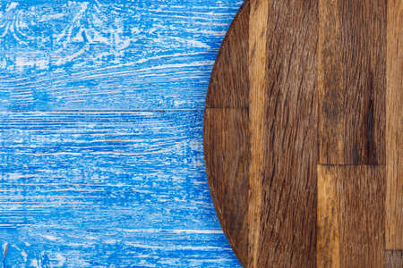 brown cutting board on a shabby blue background. place for text
