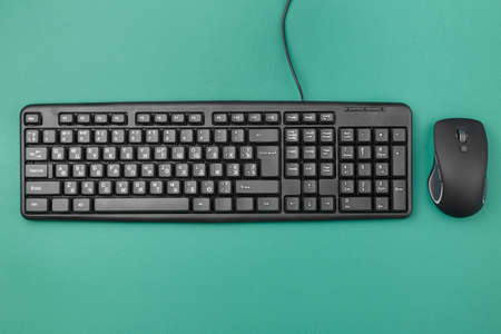 keyboard for computer with a wire on the table. nearby lies a wireless mouse. modern office equipment
の写真素材