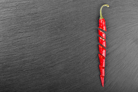 red hot chili peppers on a black slate background. place for textの写真素材