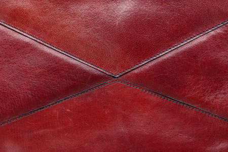 red leather background made from different pieces of leather. stitched by triangles. place for text....