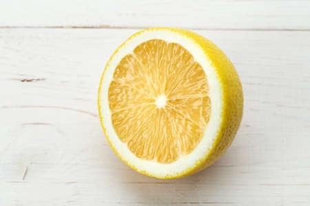 half fresh sliced lemon on a wooden background. place for text. the fruit texture is clearly visible. close-upの写真素材