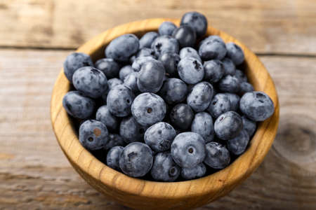 Fresh blueberries in a wooden bowl.の写真素材