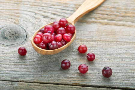 Fresh cranberries in a wooden spoon.