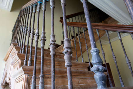 Ancient staircase with iron balusters and wooden railing.