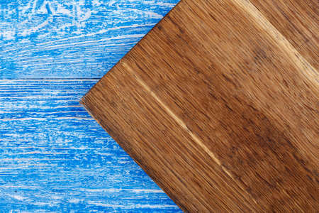 brown cutting board on a shabby blue background. place for textの写真素材