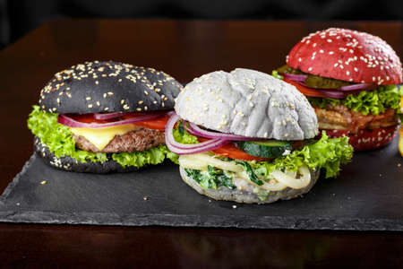 burgers in colorful buns. assortment of meat burgers with vegetablesの写真素材