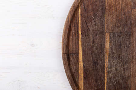 Brown cutting board on a white wooden background. View from above. Place for text.の写真素材
