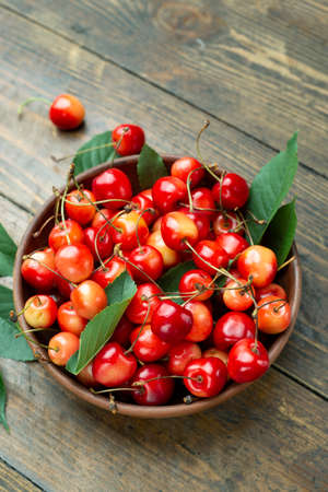 ripe tasty sweet cherries on the table, nearby are the leaves. fresh summer cropの写真素材