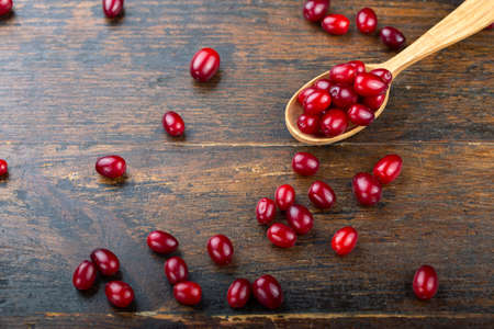 Dogwood on a wooden background. Gathering the summer harvest. Red berry.