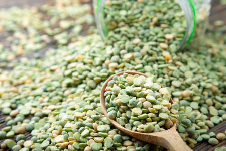 dry green peas scattered from a can on the table. place for text