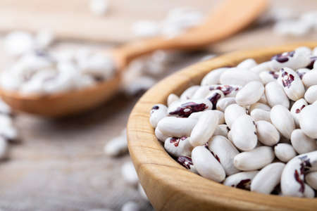 white dry beans in a wooden plate. vegetable protein, vegan productの写真素材