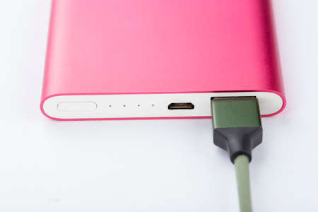 Power bank for charging mobile devices. Pink smart phone charger with power bank. battery bank. External battery for mobile devices on a white background.の写真素材
