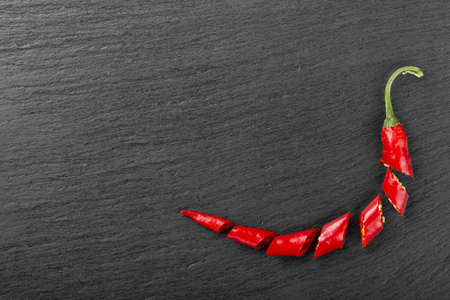 Chopped red hot peppers on a black board. Top view.の写真素材