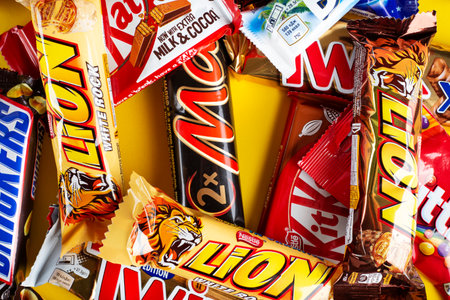 Ukraine, Kyiv - March 23, 2020: A bunch of chocolate bars, including Snickers, Twix, Milka, Kitkat, Lion, M&M, Bounty, on a yellow background.のeditorial素材