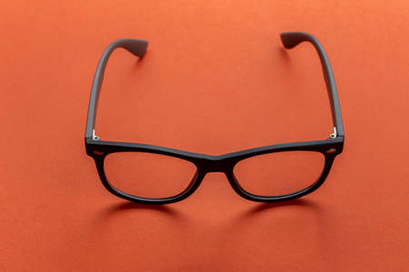 Glasses for vision in black frames on an orange background. Fashion accessories.の写真素材