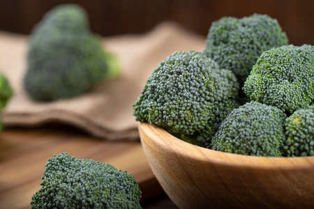 Fresh broccoli with in bowl on wooden table close up. Fiber-rich food.の写真素材