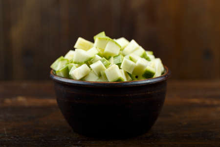 Sliced zucchini in a bowl on a wooden background. Vegetable, ingredient and staple food. Healthy food.の写真素材