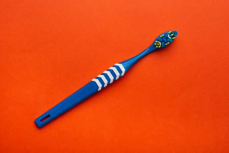 Toothbrush on orange background. Hygiene of the oral cavity. Top view. Space for text.の写真素材