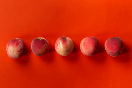 Fresh, ripe peaches on an orange background. Delicious and healthy fruits. Healthy food concept.の写真素材