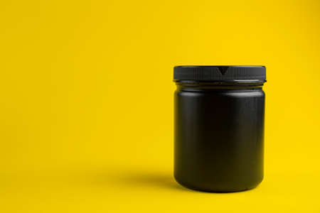 Cosmetics containers mockup. Jar or blank packaging for cosmetic product with cap on a yellow background.の写真素材