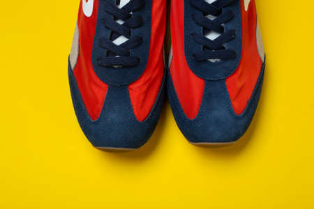 Pair of new youth sneakers on a yellow background. Lifestyle sneaker sport shoe.の写真素材