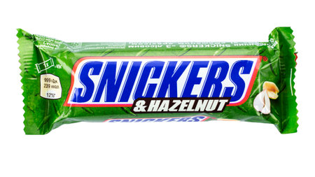 Ukraine, Kyiv - November 30.2020: Snickers chocolate bar of sweets with hazelnuts white background. Snickers is a brand name chocolate bar made by the American company Mars.のeditorial素材