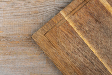 Empty cutting board on a wooden table. Space for text. View from above.